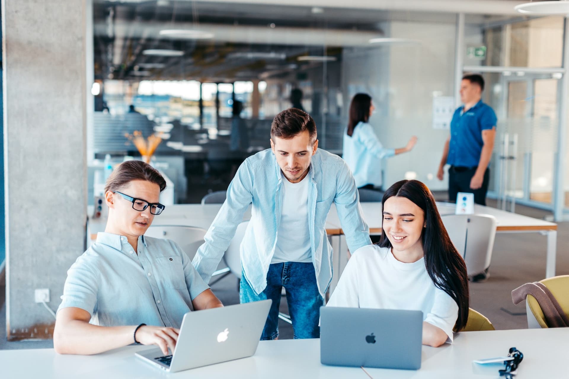 Equipe reunida em volta de uma mesa com notebooks